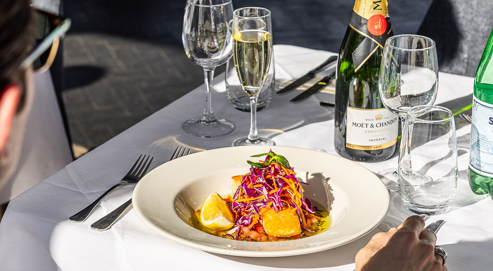 premium plated meal and drinks on a dining table on Clearview glass boat