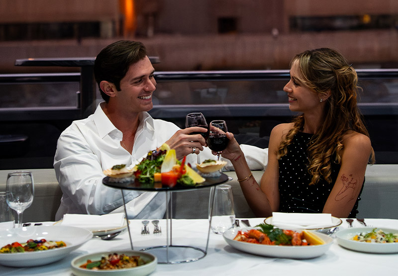 A couple enjoying wine on the Clearview 2-hour Dinner Cruise With Wine Pairing